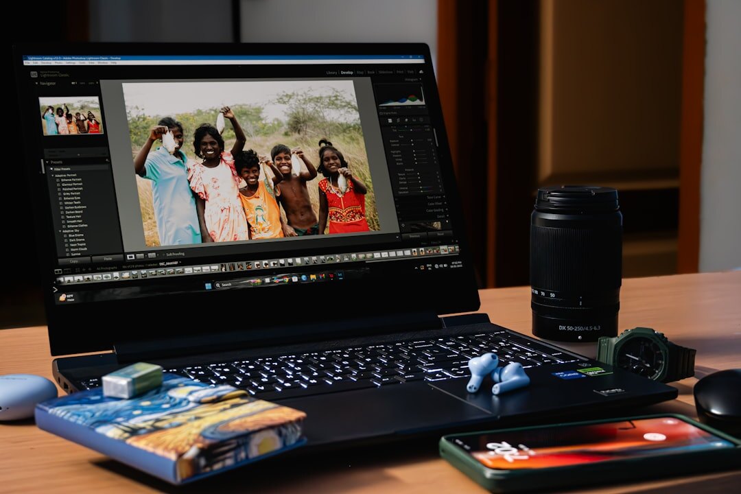 Photographer reviewing documentary photographs on a laptop at a wooden desk